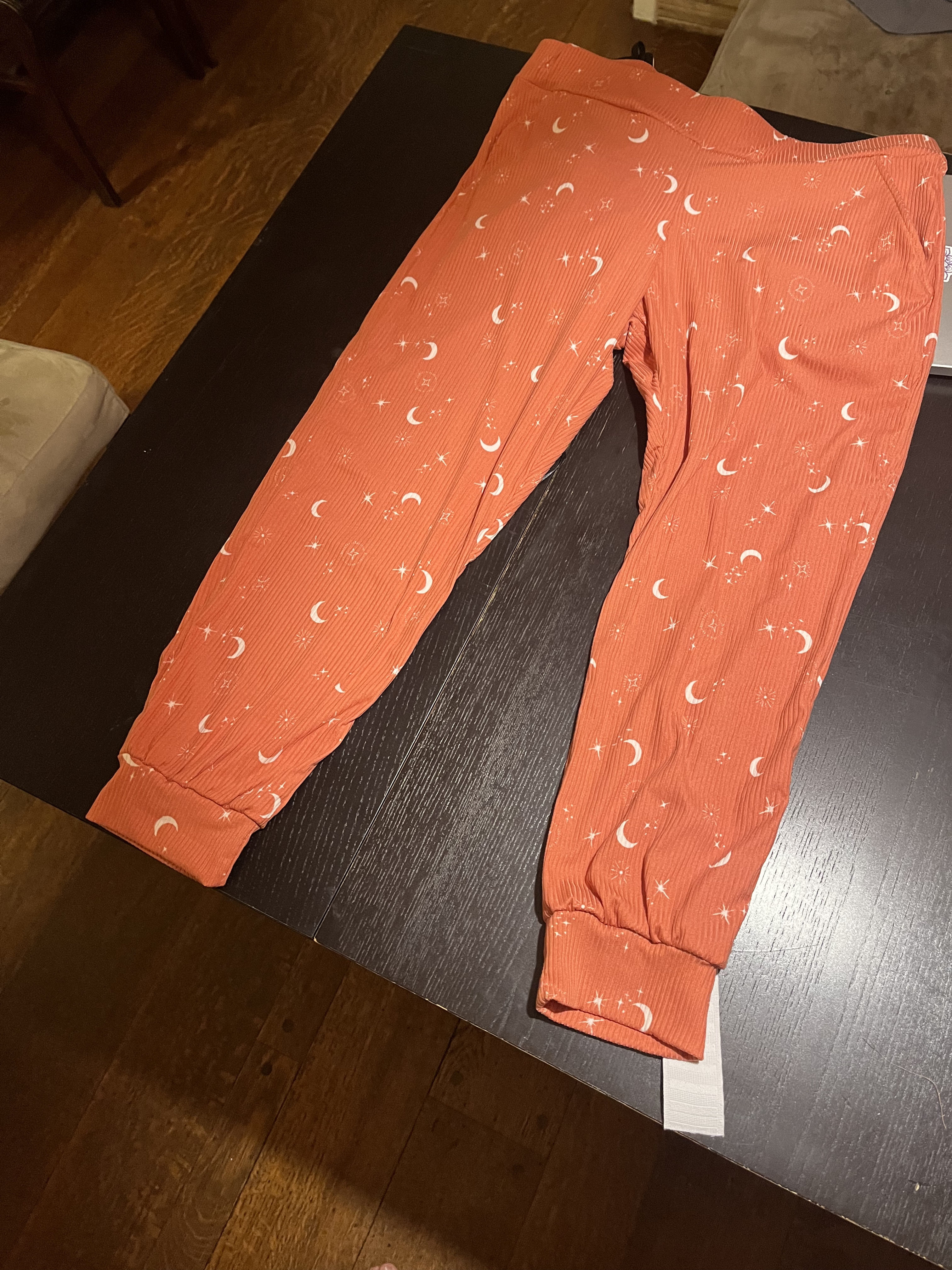 Orange-ish jogger pants with moons and stars for a kid