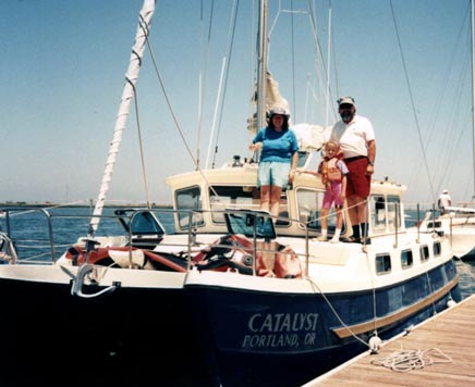 My mom, myself (age 7), and my dad standing on the deck of our catamaran Catalyst.