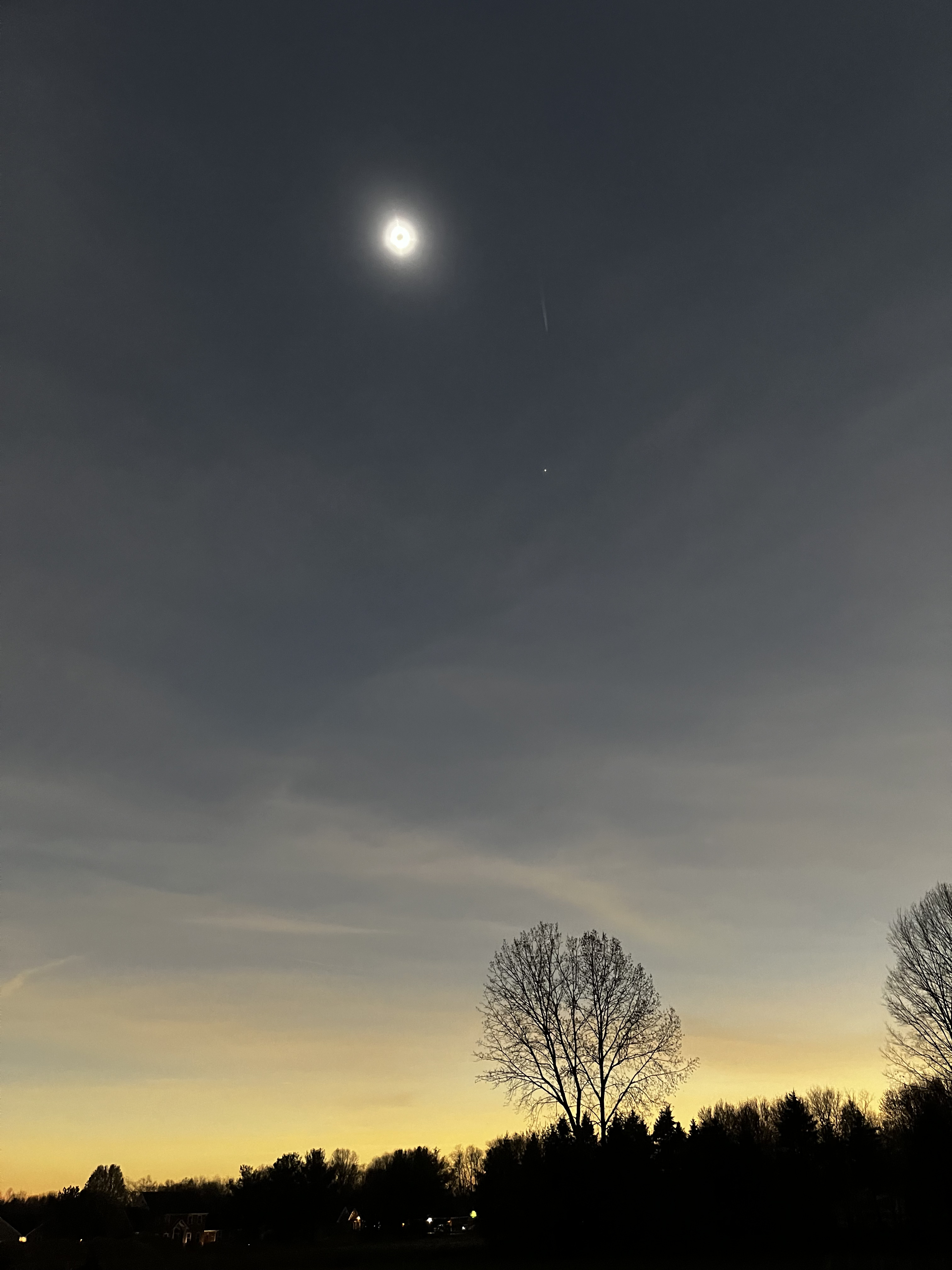 The moon blocking the sun, creating a dusky sunset glow all around the horizon.