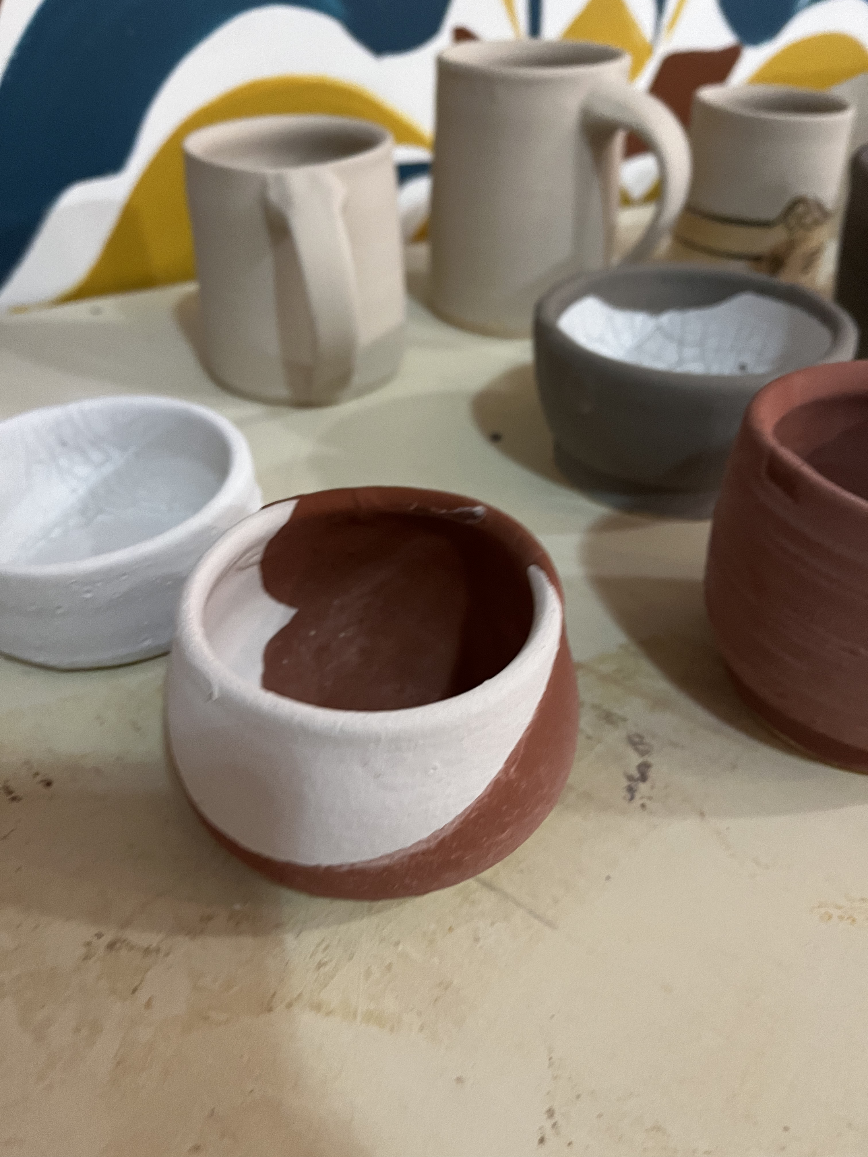 A pot with white glaze and rust brown glaze.