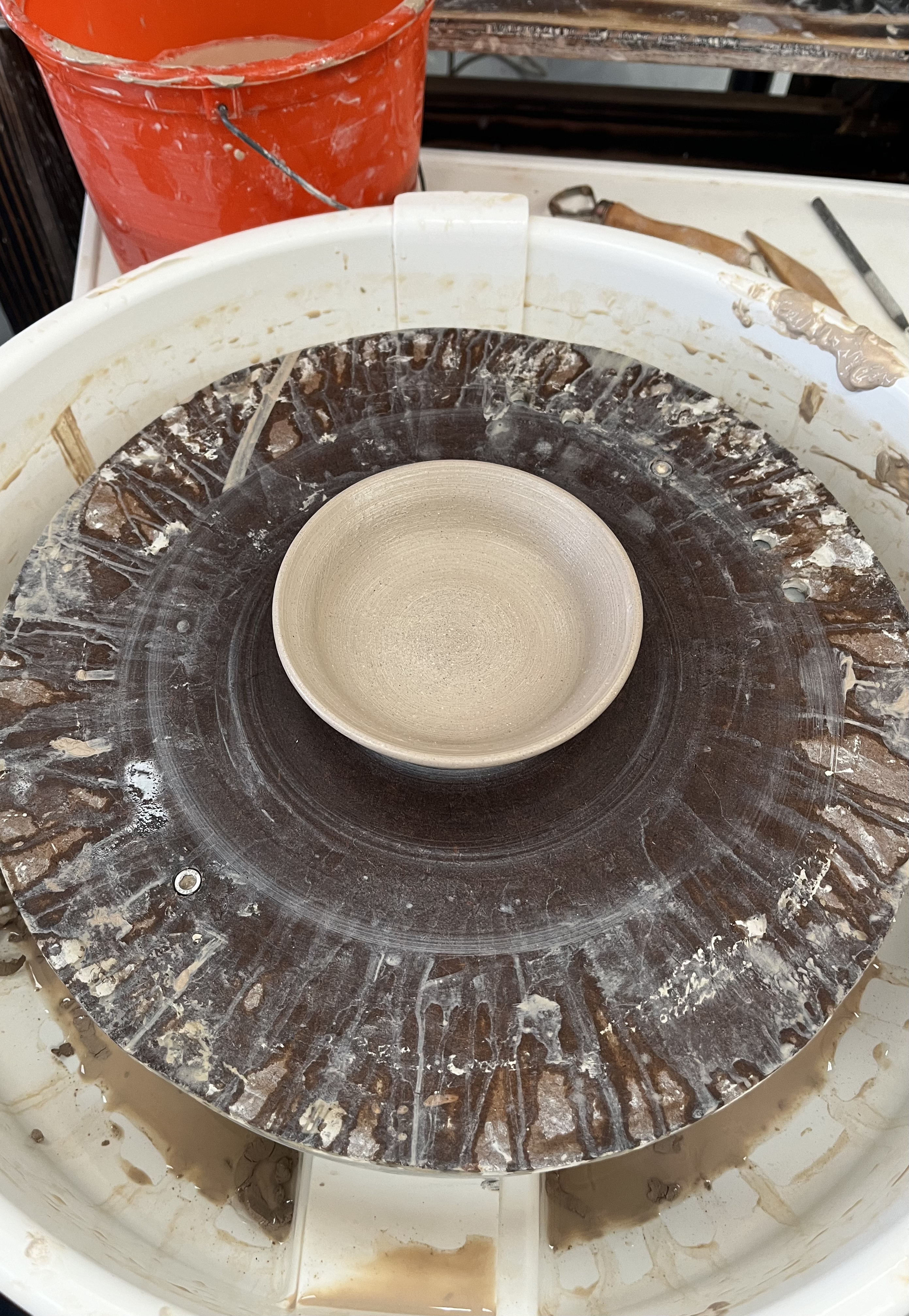 A little plate on a pottery wheel.