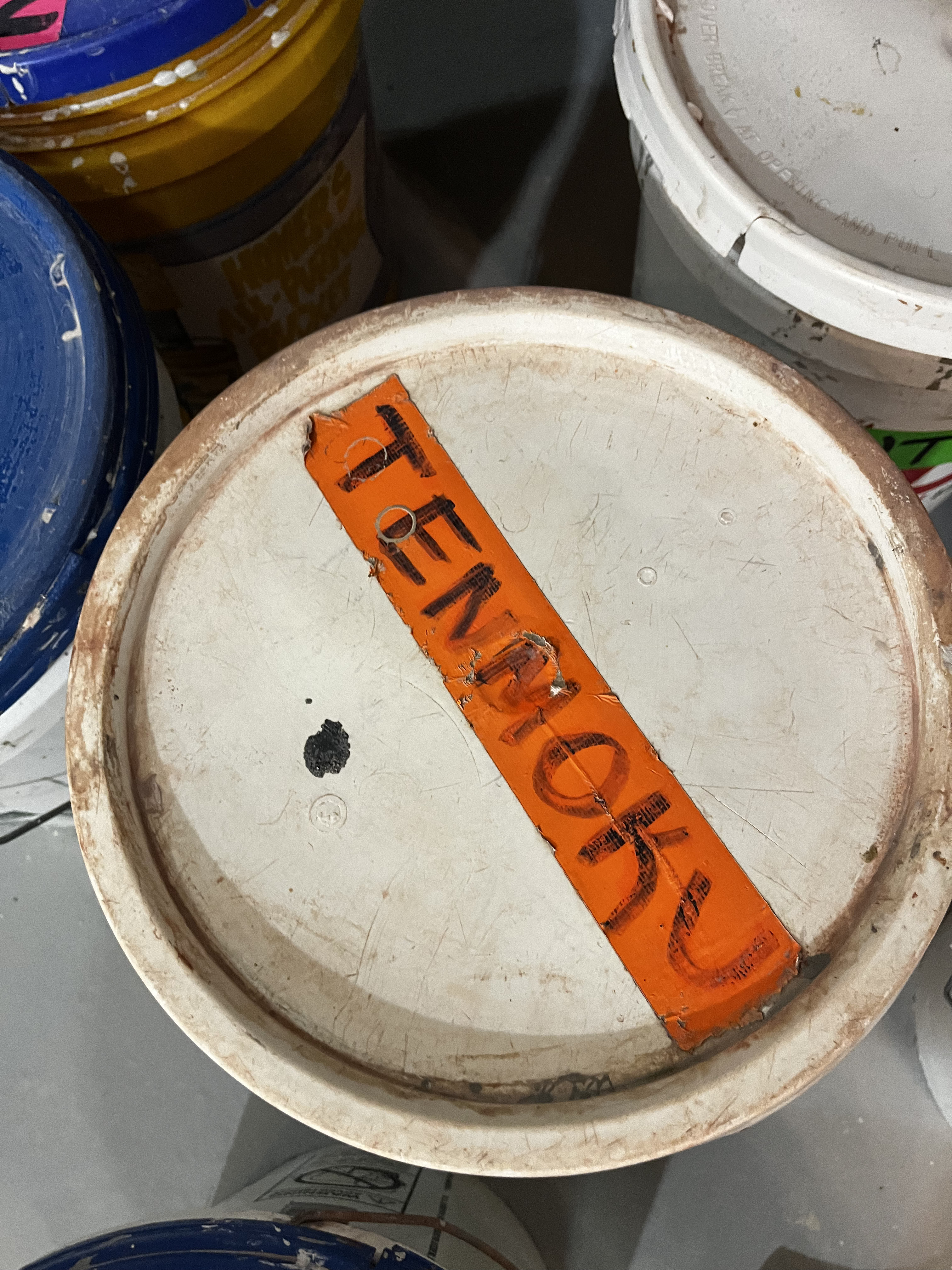 The top of a glaze bucket labeled Tenmoku.