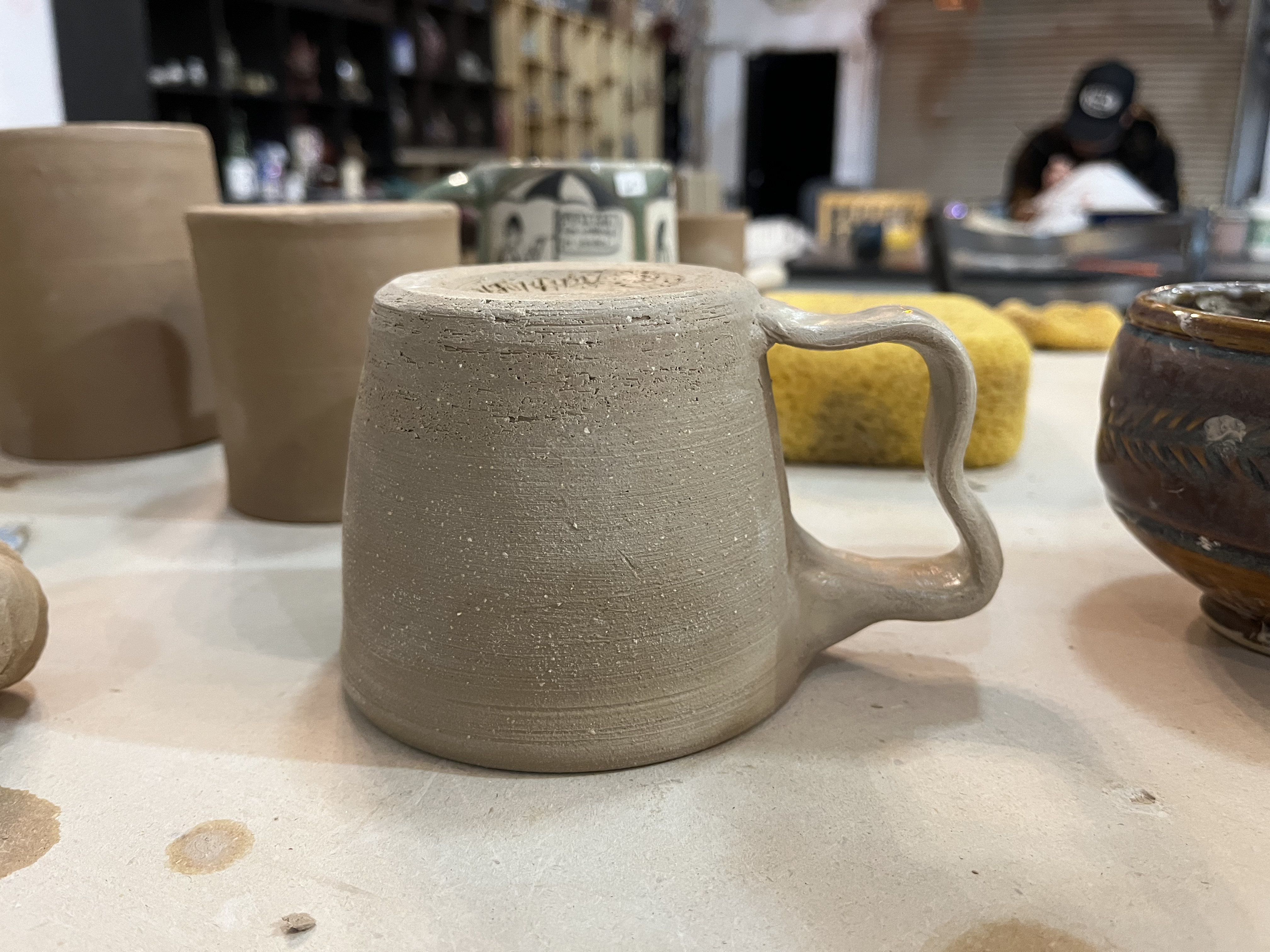 A side view of a mug with a funky handle.