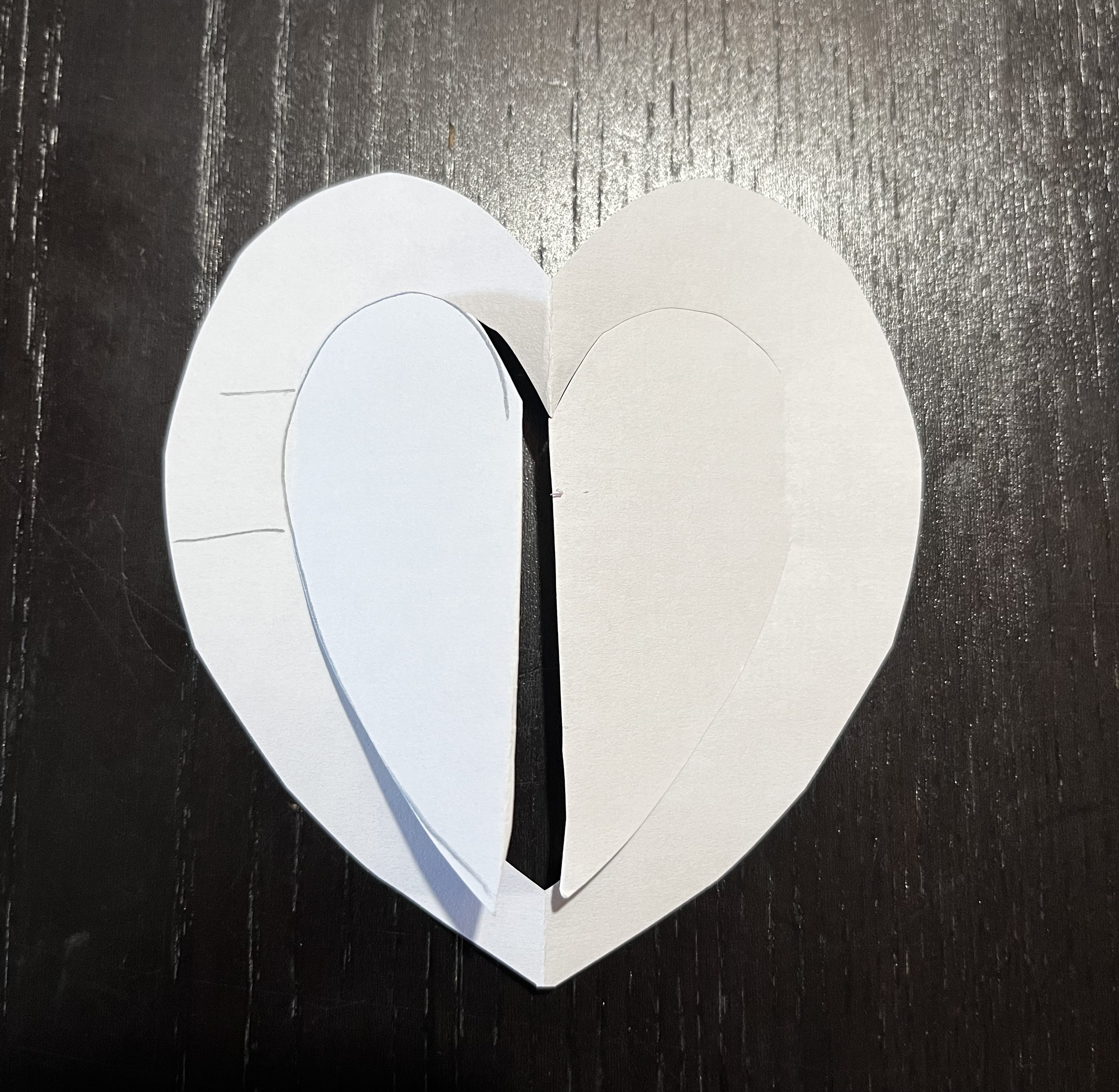 A paper prototype an outer heart frame with an inner heart shape cut out such that it can open like two little doors.